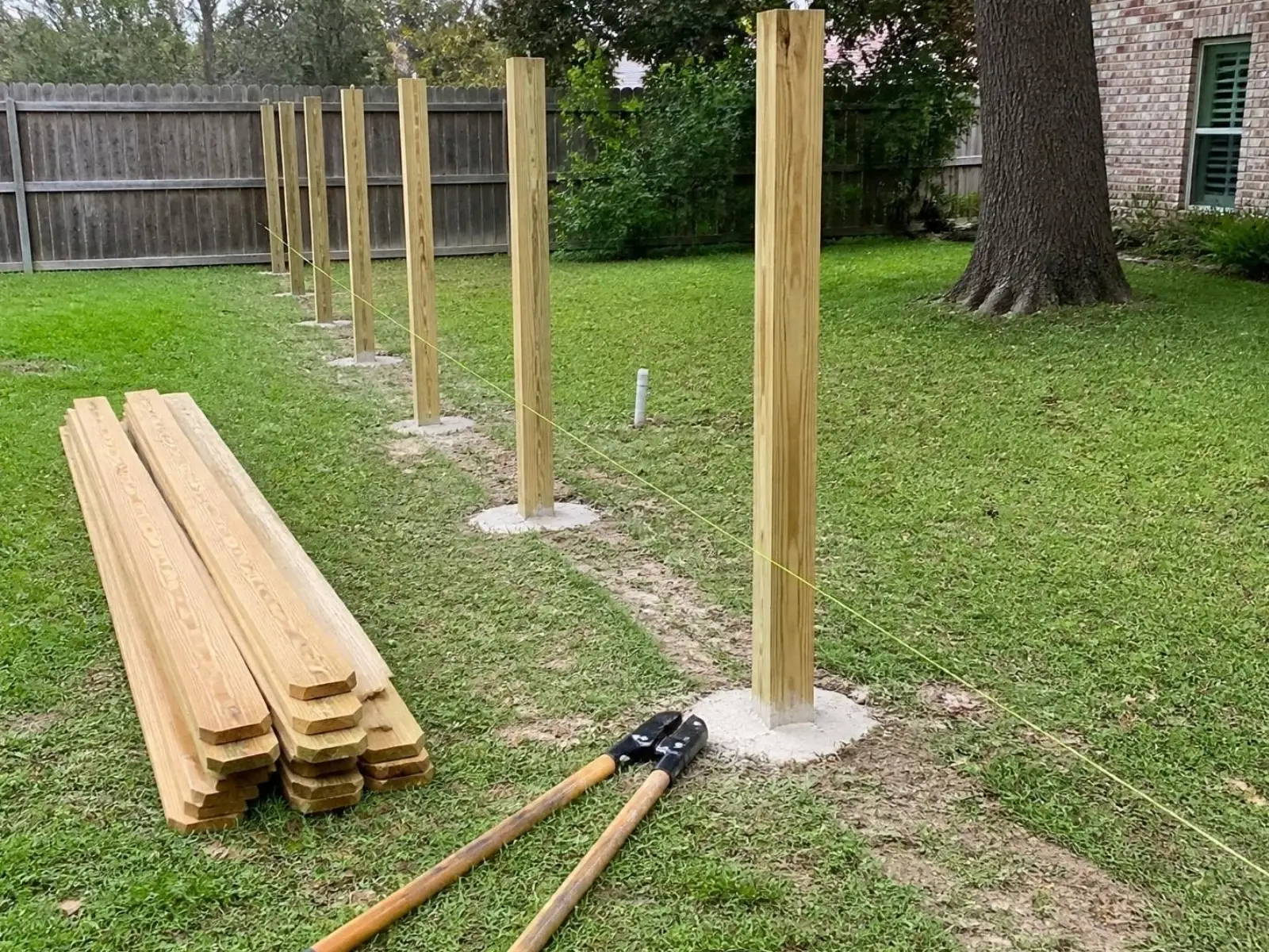 Postes nuevos plantados en concreto a lo largo de un hilo guía