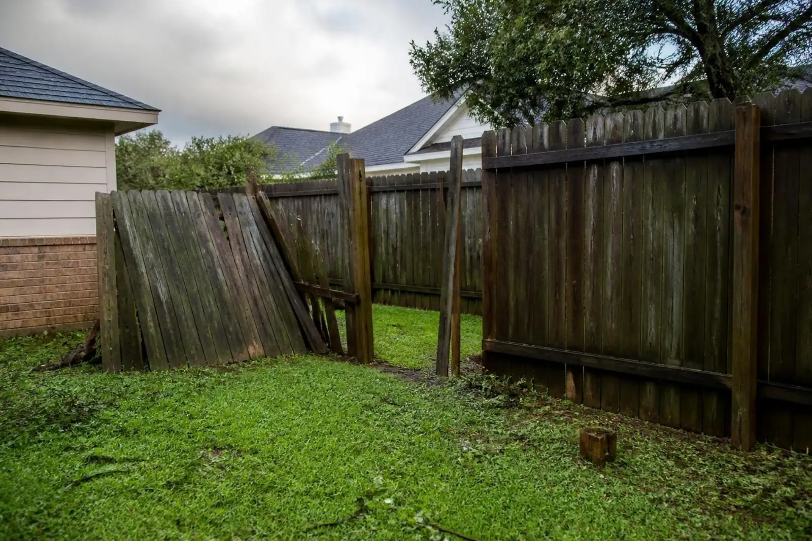 Wood fence with a section knocked down by a storm
